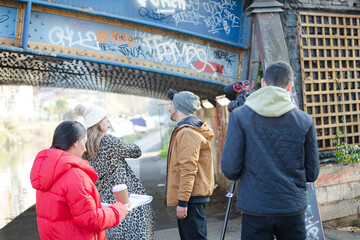 Young adults vlogging under urban bridge