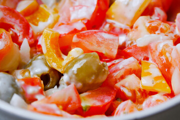 Simple home made salad with fresh tomato, olives and pepper and sour cream in a small bowl. Vegetarian food concept.