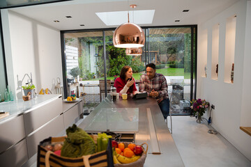 Couple financial planning at digital tablet in kitchen