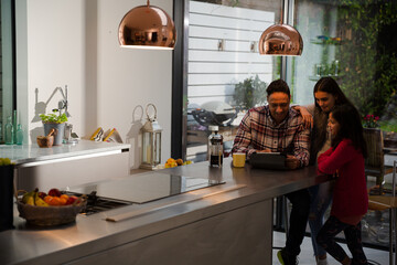Family using digital tablet at kitchen table