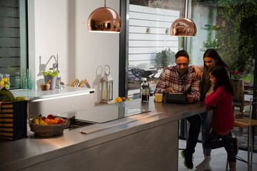 Family using digital tablet at kitchen table