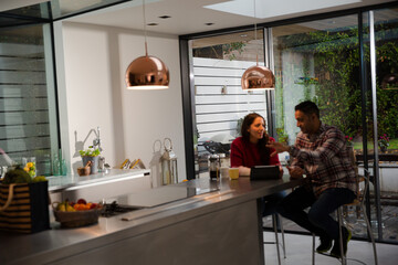 Couple financial planning at digital tablet in kitchen