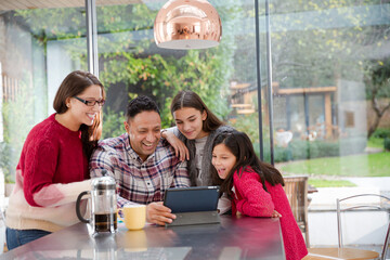 Happy family planning vacation at digital tablet in kitchen