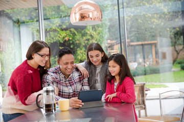 Happy family planning vacation at digital tablet in kitchen
