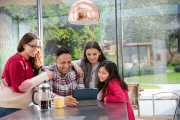 Happy family planning vacation at digital tablet in kitchen
