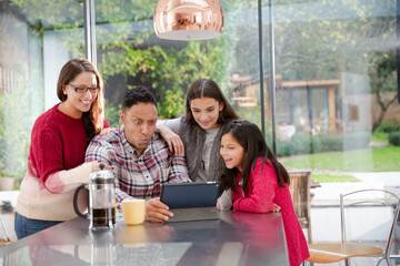 Happy family planning vacation at digital tablet in kitchen