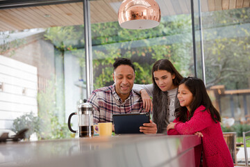 Happy family planning vacation at digital tablet in kitchen