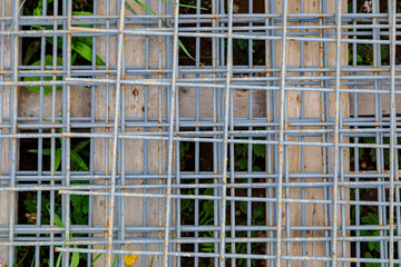 Steel wire mesh used in construction. A metal mesh lies on a wooden pallet at a construction site.