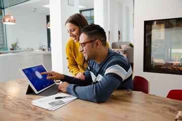 Couple paying bills online, using fingerprint log on at digital tablet