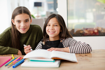 Girl helping young sister with homework