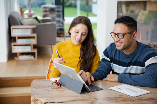 Couple using digital tablet at kitchen island