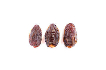 Three dried dates on white isolated background.Close up view.