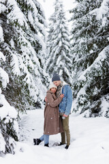 Fototapeta na wymiar cute couple embracing in winter forest.