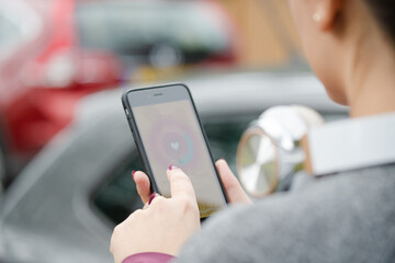Female runner checking heart rate monitor on smart phone on path