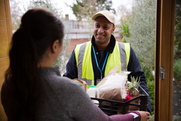 Woman greeting food deliveryman at front door