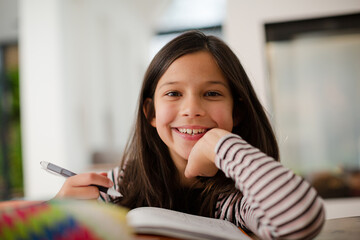 Portrait confident, smiling girl doing homework