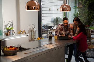 Family using digital tablet at kitchen table