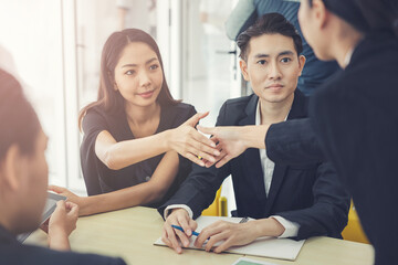 Young businesswoman shaking hands with colleagues in conference room