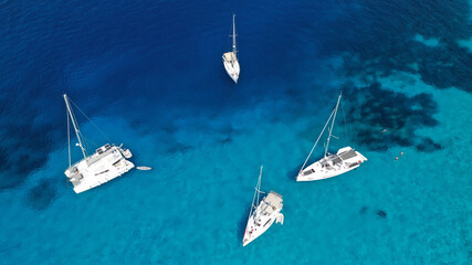 Aerial drone photo of beautiful sail boat anchored in tropical exotic island bay with turquoise...
