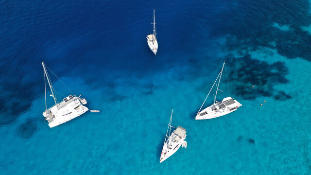 Aerial drone photo of beautiful sail boat anchored in tropical exotic island bay with turquoise clear sea