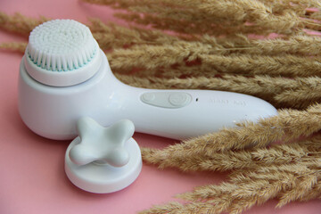 spa treatments. massager with different attachments on a pink background