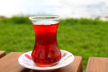 glass of tea on a table with sea background