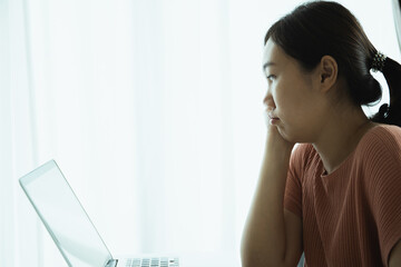 Young Asian woman bored in online meeting and work from home.