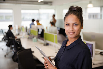 Fototapeta premium Portrait of confident businesswoman in open plan office