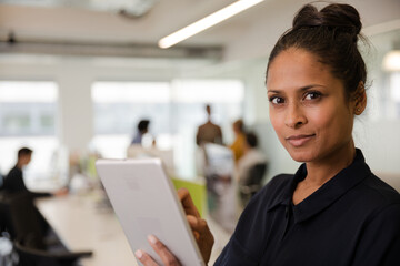 Fototapeta premium Portrait of confident businesswoman in open plan office