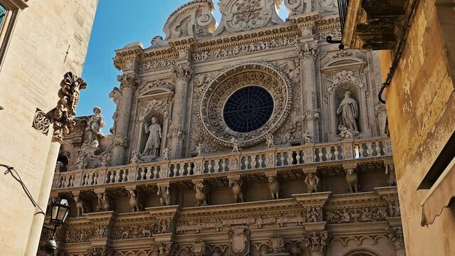Lecce, Puglia, Italy. August 2021. The Basilica of Santa Croce is the finest example of the Lecce Baroque. The tilt footage highlights the richness of the facade details. Beautiful summer day.