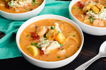 Bowls of Shrimp and Crab Bisque with Garnish: Seafood bisque topped with crab salad, croutons, and...