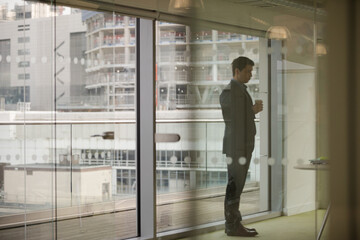 Businessman standing by window in conference room