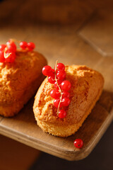 close up vanilla baked cupcakes with currants on a wooden table