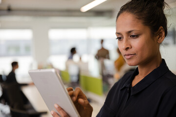 Portrait of confident businesswoman in open plan office