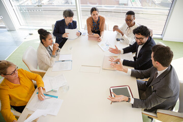 Business people discussing paperwork in conference room