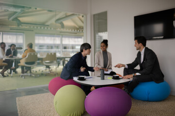 Business people discussing paperwork in relax zone
