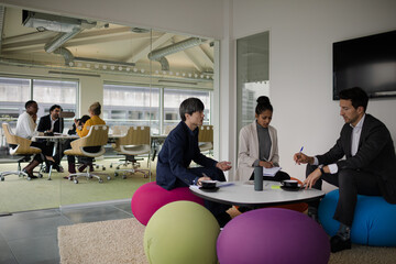 Business people discussing paperwork in relax zone