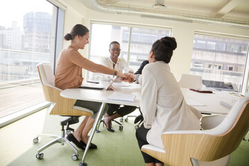 Happy business people touching hands, celebrating success in conference room