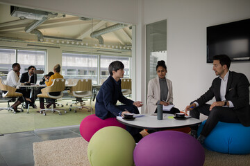 Business people discussing paperwork in relax zone