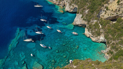 Aerial drone photo of sail boats anchored in tropical Caribbean island paradise bay with white rock...