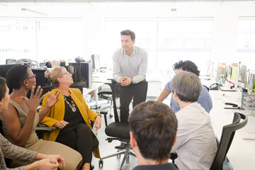 Business people meeting at computer in open plan office