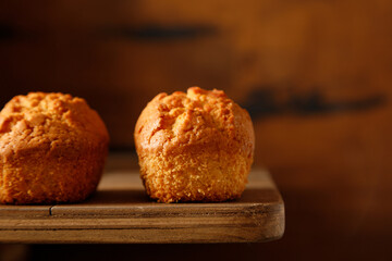close up vanilla baked cupcakes with currants on a wooden table