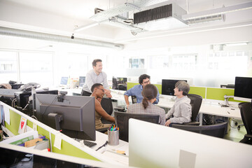 Business people meeting at computer in open plan office