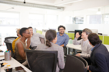 Business people meeting at computer in open plan office