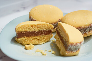 Traditional Argentinian alfajores with dulce de leche on marble table. Argentine gastronomy concept.