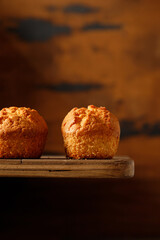 close up vanilla baked cupcakes with currants on a wooden table