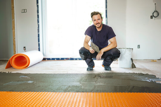 Man Worker Install Orange Roll Membrane Waterproofing On The Floor