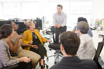 Business people meeting at computer in open plan office