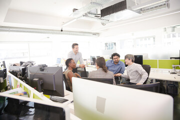 Business people meeting at computer in open plan office