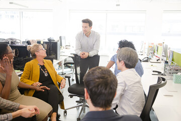 Business people meeting at computer in open plan office